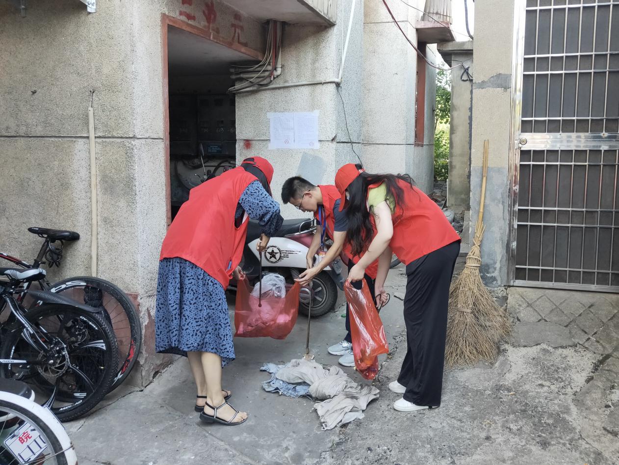 黨員志愿者清掃樓道垃圾。東至縣委宣傳部供圖