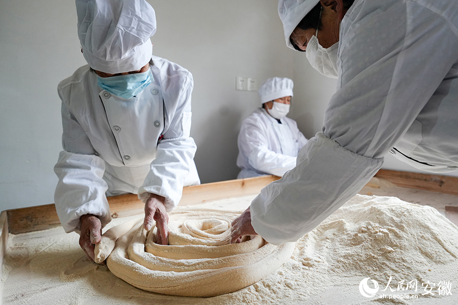 工人將拉長的糖條盤成卷。人民網(wǎng)記者 苗子健攝