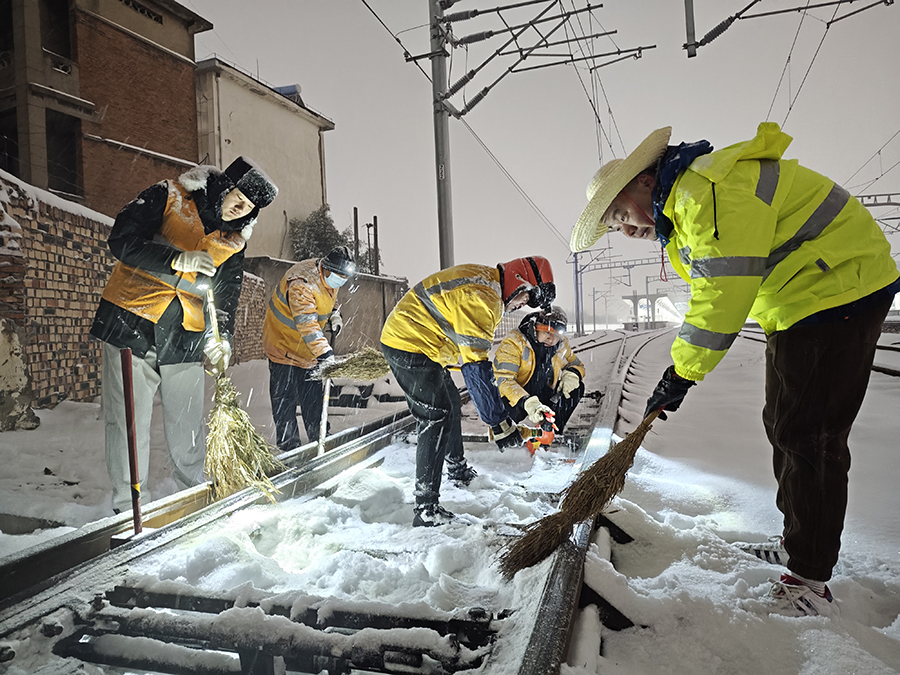 掃雪突擊隊員子夜冒雪清掃道岔積雪保列車安全暢通。宿州火車站供圖