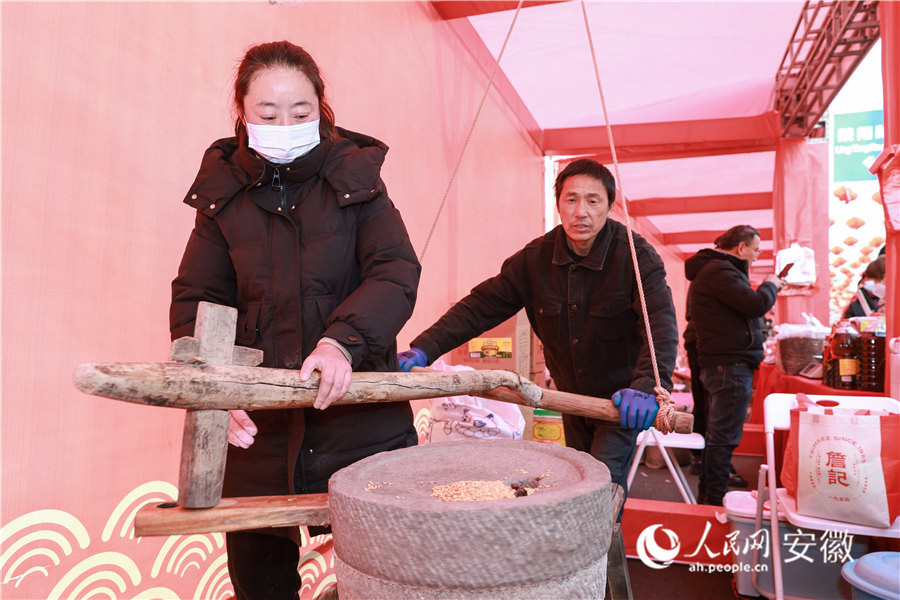 南陵年貨集市，攤主現(xiàn)場磨制銷售渣肉粉。人民網記者 張俊攝