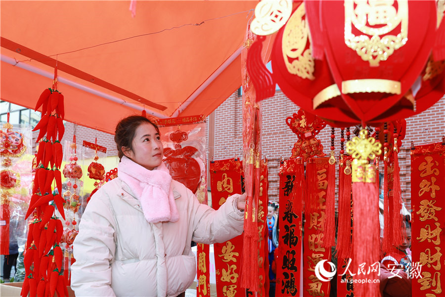 南陵年貨集市，居民挑選新年裝飾品。人民網(wǎng)記者 張俊攝