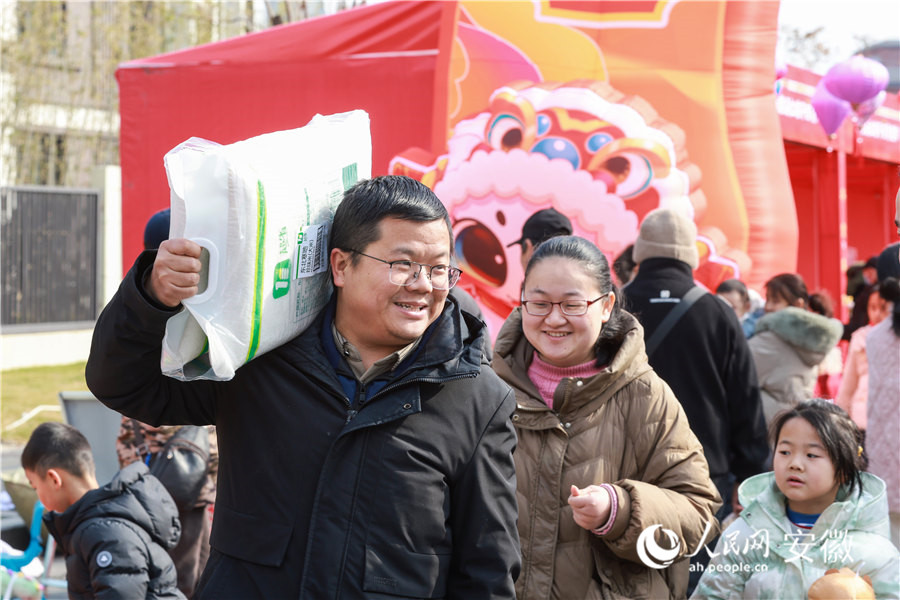 安徽南陵年貨集市，一位市民扛著挑選好的年貨返回。人民網(wǎng)記者 張俊攝