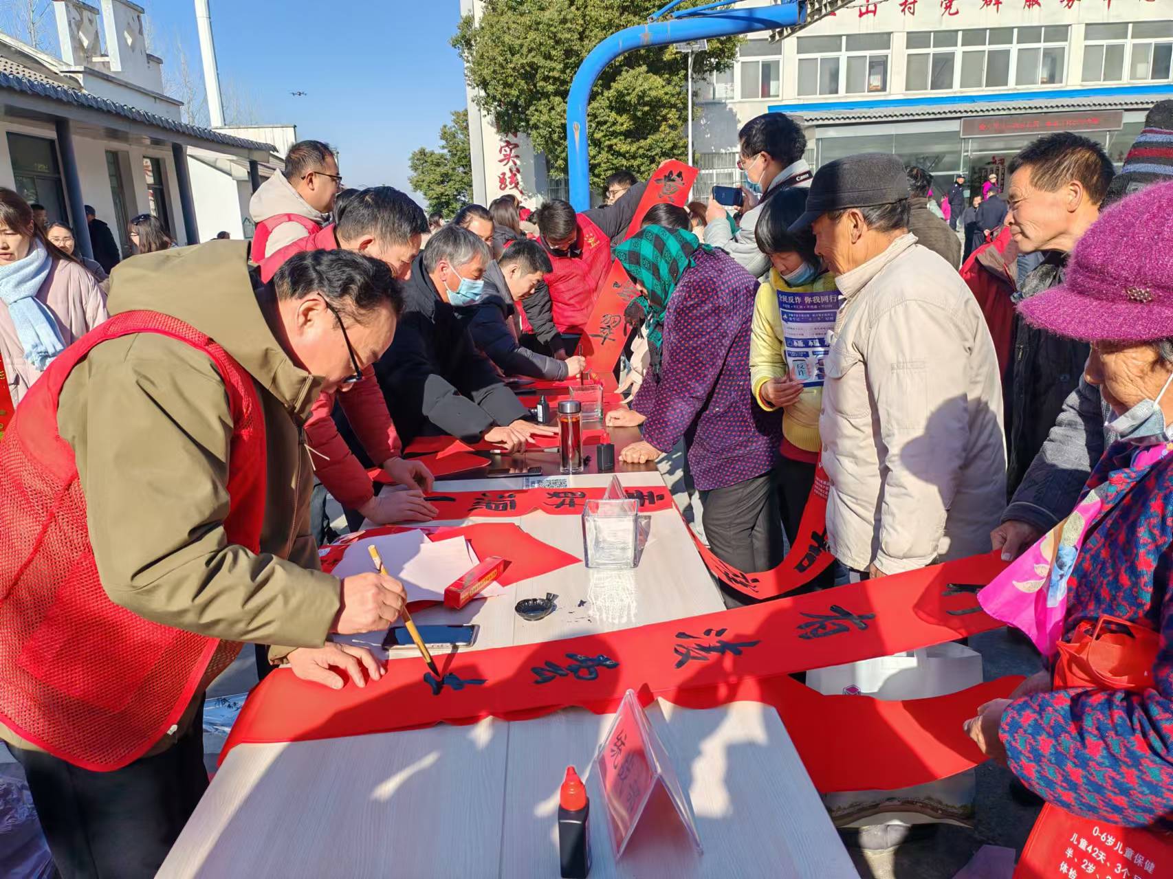 “畫書南譙”志愿者為村民寫春聯(lián)。南譙區(qū)委宣傳部供圖