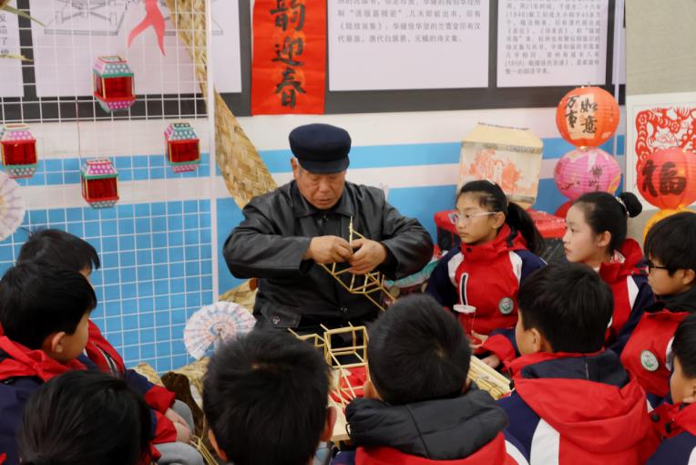 同學(xué)們認(rèn)真學(xué)習(xí)如何制作花燈。