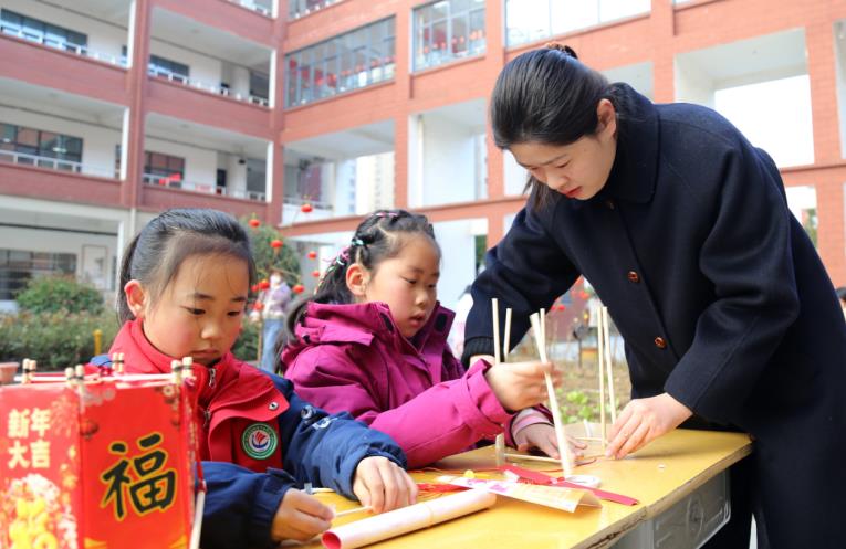 同學(xué)們在老師指導(dǎo)下制作花燈。